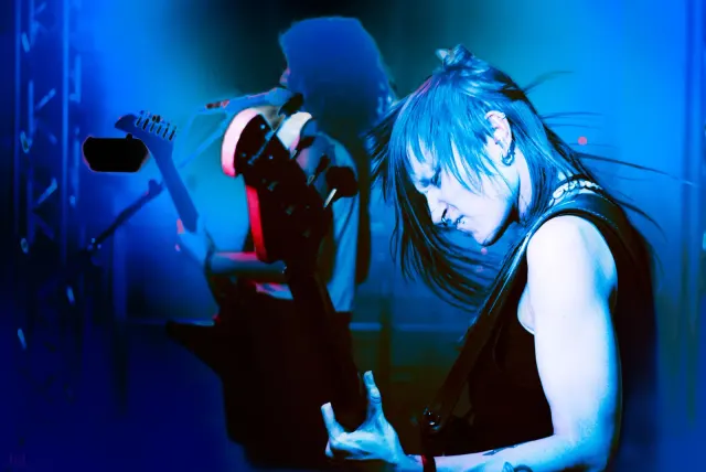 Bassistin live on Stage, blaues Licht, Bewegung, Konzertatmosphäre